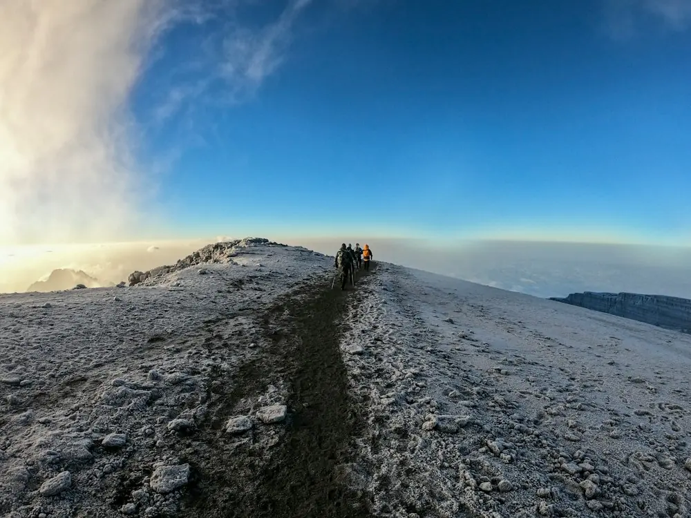 Trekkers walking a frosted ridge at first light